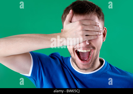 Porträt des jungen Mannes schließen der Augen mit der Hand und schrie Stockfoto