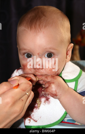 Ein junges Baby junge dem Absetzen von der Milch und an Essen, schmutzige Geschäft Stockfoto