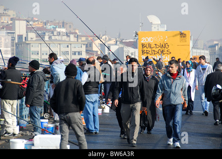 ISTANBUL, TÜRKEI. Menschen über Wandern und Fischen von der Galata-Brücke mit Karakoy Bezirk im Hintergrund. 2010. Stockfoto