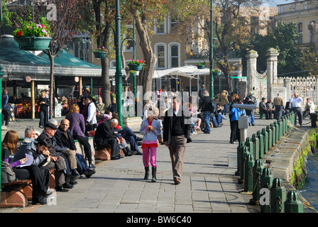 ISTANBUL, TÜRKEI. Menschen sitzen und gehen durch die Bosporus-Ufergegend an Ortakoy im Stadtteil Besiktas. 2010. Stockfoto