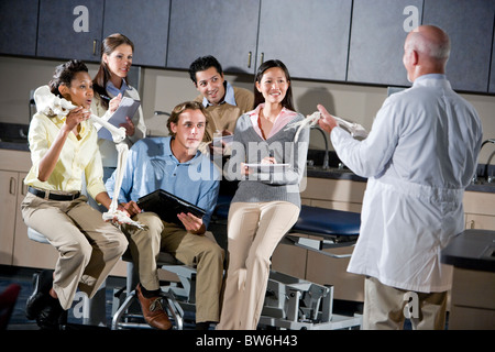 Medizinstudenten in der Klasse mit Professor, diskutieren Knochenstruktur Stockfoto