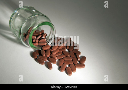 Generika Pillen Spill aus einer klaren Glasflasche Stockfoto