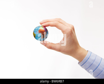 Nahaufnahme von weiblicher Hand hält Globus Modell auf weißem Hintergrund Stockfoto