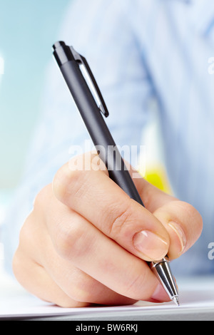 Bild von weiblicher Hand mit Stift auf Papier Stockfoto