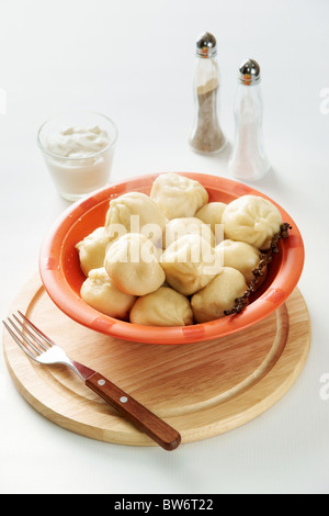 Bild von leckeren Knödel in Plastikschüssel serviert mit Sauerrahm Stockfoto
