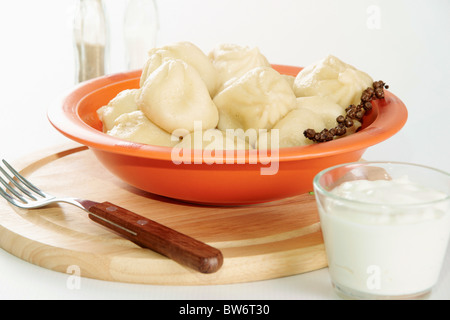 Bild von leckeren Knödel in Plastikschüssel serviert mit Sauerrahm Stockfoto