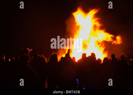 Festivals, Guy Fawkes, Lagerfeuer, Menschen Silhouette durch Flammen aus Feuer am Strand. Stockfoto