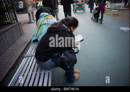 Ein Leser nutzt ihr Amazon Kindle elektronische Buch am Herald Square in New York Stockfoto