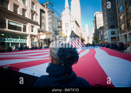 Demonstranten tragen eine riesige amerikanische Flagge in der 91. Jahrestag von der Veterans-Day-Parade in New York Stockfoto