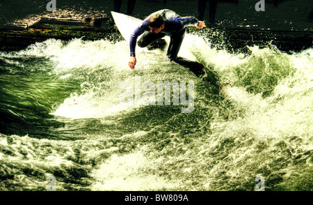 Surfen an Isar, auf der Eisbach-Welle, in der Nähe von Haus der Kunst, eine neue touristische Attraktion in München. Stockfoto