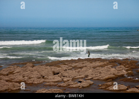 Ein Fischer mit Meereswellen an der Corniche in Casablanca, Marokko. Stockfoto