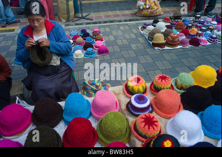 Frau stricken und Hüte auf Bürgersteig, Otavalo, Imbabura, Ecuador zu verkaufen Stockfoto