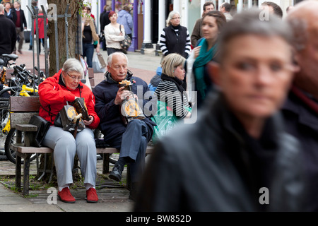 zwei ältere Menschen Essen zum Mitnehmen cornish Pasties auf einer Stadt-High-Street-Bank Stockfoto