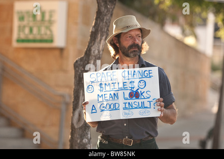 Ein bärtiger Mann sucht nach Kleingeld auf Sixth Street außerhalb der Whole Foods Supermarkt in der Innenstadt von Austin Texas Stockfoto