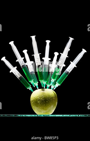 Spritzen in einen Apfel stecken Stockfoto