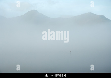 Nebligen Morgen Blick auf Catbells über Derwentwater. Eine Flagge nur sichtbar markiert eine flache im See Stockfoto