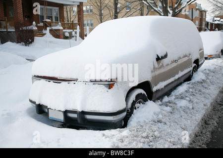 Schnee bedeckt und umgibt ein Suv-Auto oder LKW geparkt auf einer Stadtstraße im winter Stockfoto