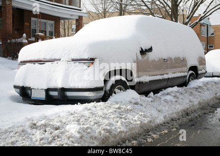 Schnee bedeckt und umgibt ein Suv-Auto oder LKW geparkt auf einer Stadtstraße im winter Stockfoto