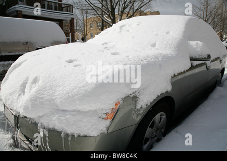 Schnee bedeckt und umgibt ein Auto auf einer Straße im winter Stockfoto