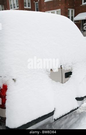 Schnee umgibt und deckt eine SUV-Auto in einer Seitenstraße Stadt im winter Stockfoto