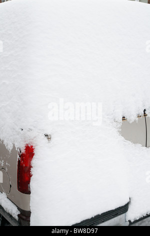 Schnee umgibt und deckt eine SUV-Auto in einer Seitenstraße Stadt im winter Stockfoto