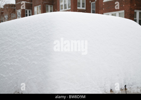 Schnee umgibt und deckt eine SUV-Auto in einer Seitenstraße Stadt im winter Stockfoto