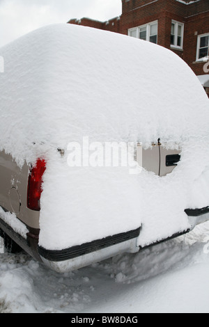 Schnee umgibt und Abdeckungen und SUV-Auto parkten in einer Seitenstraße Gepflügtes Stadt im winter Stockfoto