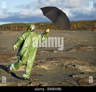 Die komische Person im schützenden wissenschaftliche Overall mit einem Regenschirm in der hand Stockfoto