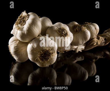 Zopf von Knoblauch Zwiebeln Nahaufnahme auf Reflexion auf schwarzem Hintergrund isoliert Stockfoto