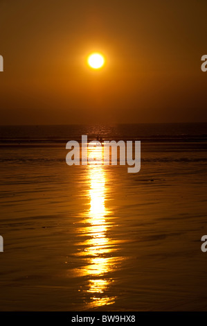 Zwei Menschen zu Fuß am Strand bei Sonnenuntergang, Westward Ho! Devon, UK Stockfoto
