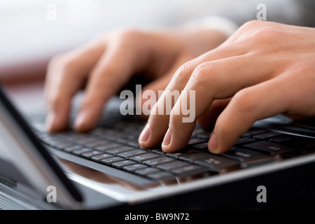 Nahaufnahme der männlichen Finger tippen ein Geschäftsdokument auf dem schwarzen laptop Stockfoto