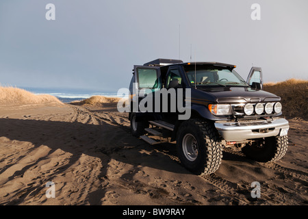 Eine modifizierte Ford e-350 auf einem schwarzen Vulkanstrand, südwestlich von Island. Stockfoto