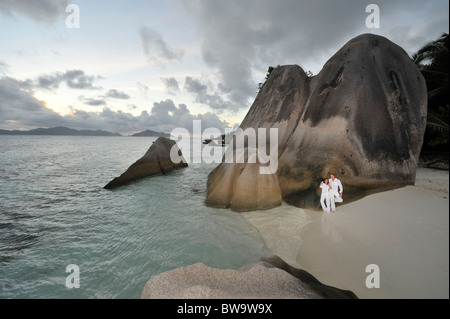 Paar steht vor Granit Felsen auf Pointe Source D´ Argent, La Digue, Seychellen Stockfoto