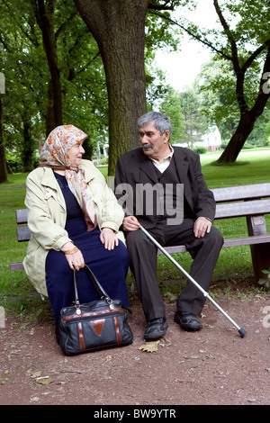 Ein älteres türkischen Ehepaar sitzt auf einer Bank in einem Park, Herne, Deutschland Stockfoto