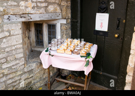 Kuchen für den Verkauf außerhalb ein Cottage, Castle Combe Wiltshire England Stockfoto