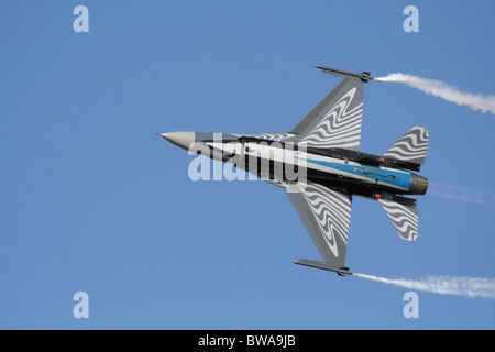 Belgisches F-16 Kampfflugzeug, das während einer Fluganzeige am Himmel fliegt. Unterseite. Nicht zentrierte Komposition mit Kopierbereich. Stockfoto