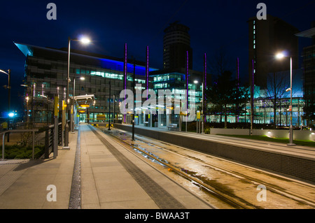 Die Metrolink-Straßenbahnhaltestelle MediaCityUK bei Nacht, Salford Quays, Manchester, Großbritannien. Stockfoto
