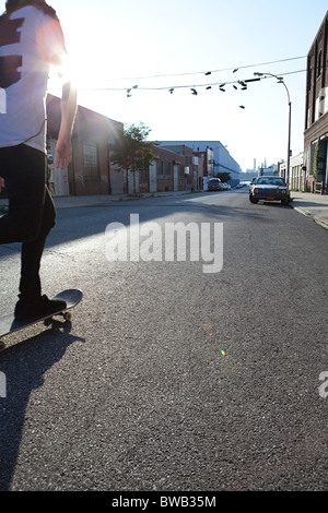Skateboarder in städtischen Straße im Sonnenlicht Stockfoto