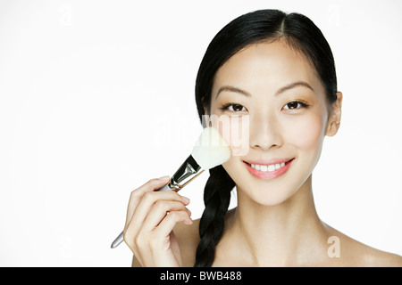 Junge Frau mit Make-up Pinsel Stockfoto