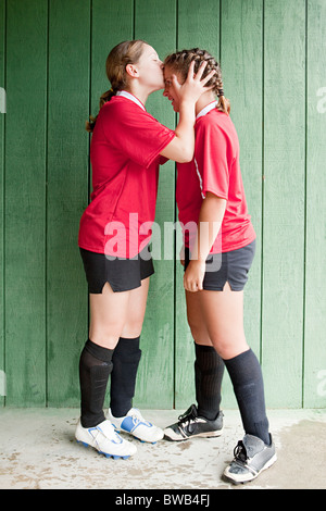 Mädchen-Fußball-Spieler küssen Teamkollege Stockfoto