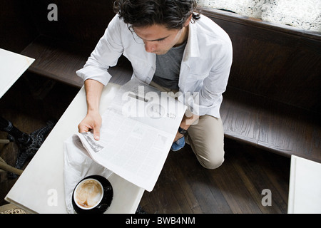 Mann liest Zeitung im Coffee-shop Stockfoto