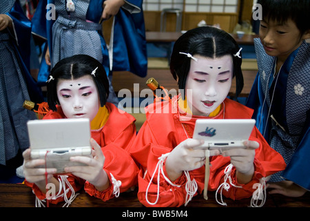 Jungen spielen elektronischer Spiele vor der Feier der Matsuri Festival in Kitano gemeinsam-gu-Schrein-Kyoto City, Japan. Stockfoto