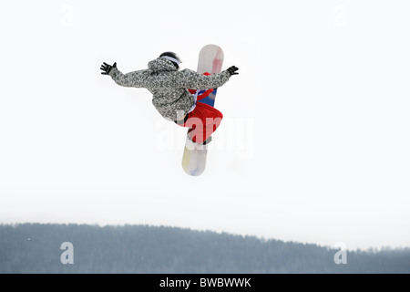 Bild der mutigen Kerl auf Snowboarder in die Luft springen Stockfoto