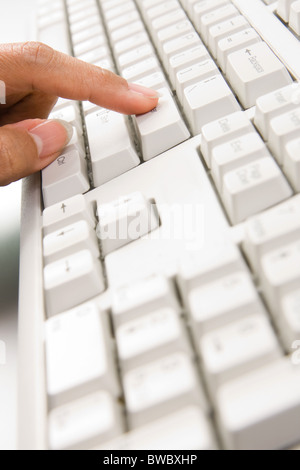 Nahaufnahme des weiblichen Zeigefinger drücken enter-Taste der Tastatur Stockfoto