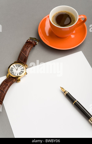 Bild des leeren Papierbogen mit Füllfederhalter, Uhren- und rote Tasse Kaffee am Arbeitsplatz Stockfoto