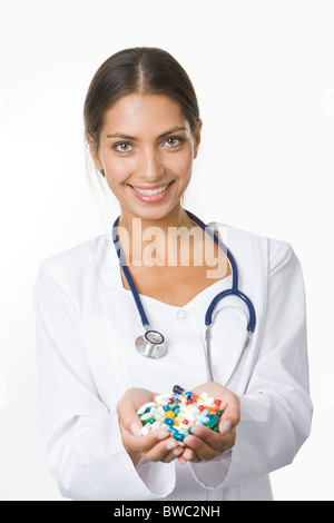 Porträt von glücklich Apotheker mit Handvoll Vitamine Blick in die Kamera Lächeln Stockfoto