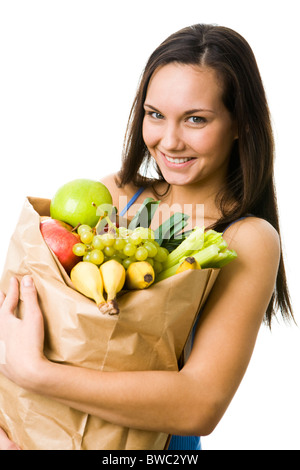 Porträt von hübschen Mädchen mit großen Papiertüte in Händen voller verschiedener Früchte und Gemüse Stockfoto