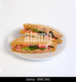 Essen, Mahlzeit, Snack, Speck-Salat und Tomate BLT dunkles Brot Sandwich auf einem weißen Teller vor einem weißen Hintergrund. Stockfoto