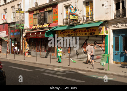 Sommer Sonntag Nachmittag, während die meisten Geschäfte geschlossen sind, fegt ein Angestellter der Stadt Paris den Bürgersteig. Stockfoto