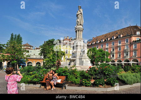 Touristen posieren vor der Statue von Walther von der Vogelweide am Waltherplatz in Bozen / Bozen, Dolomiten, Italien Stockfoto